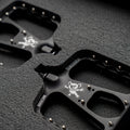 Dropbear pedals with koala logo on the pedal. Surrounded by a foam padding. Dark surrounding
