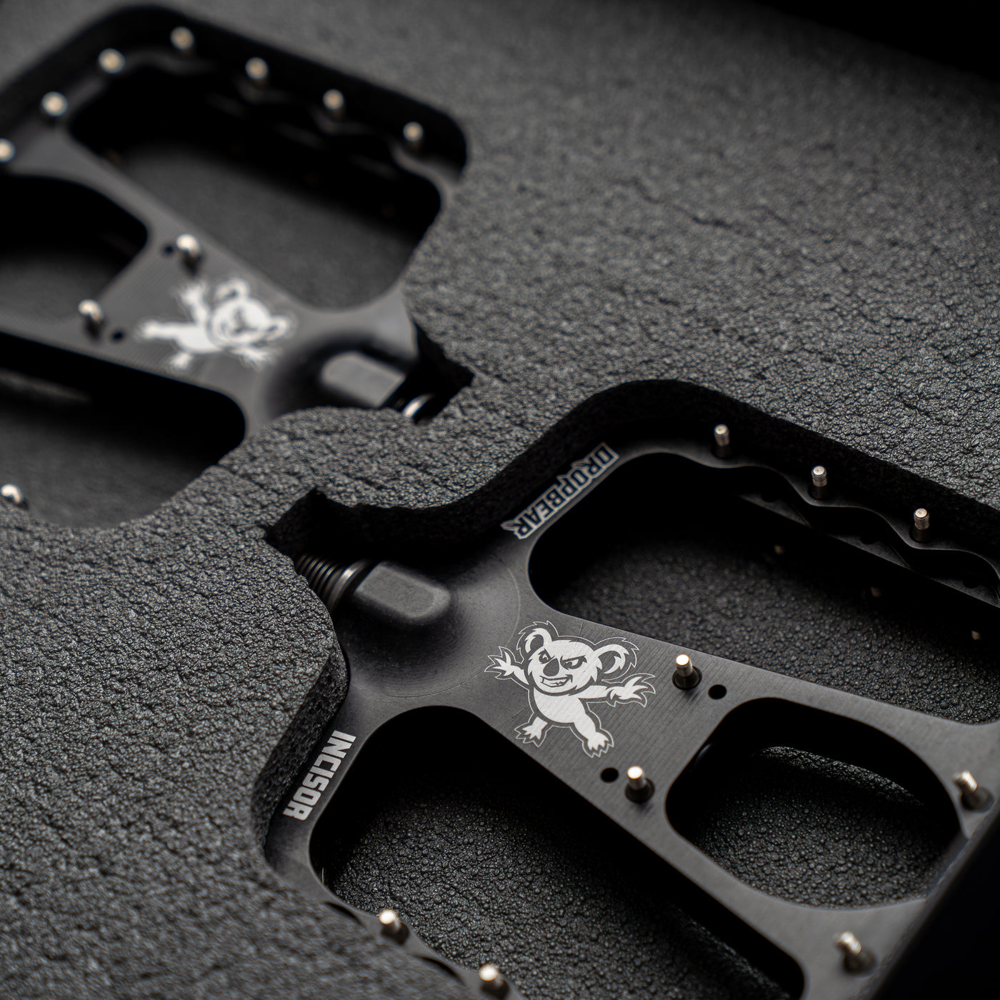 Dropbear pedals with koala logo on the pedal. Surrounded by a foam padding. Dark surrounding