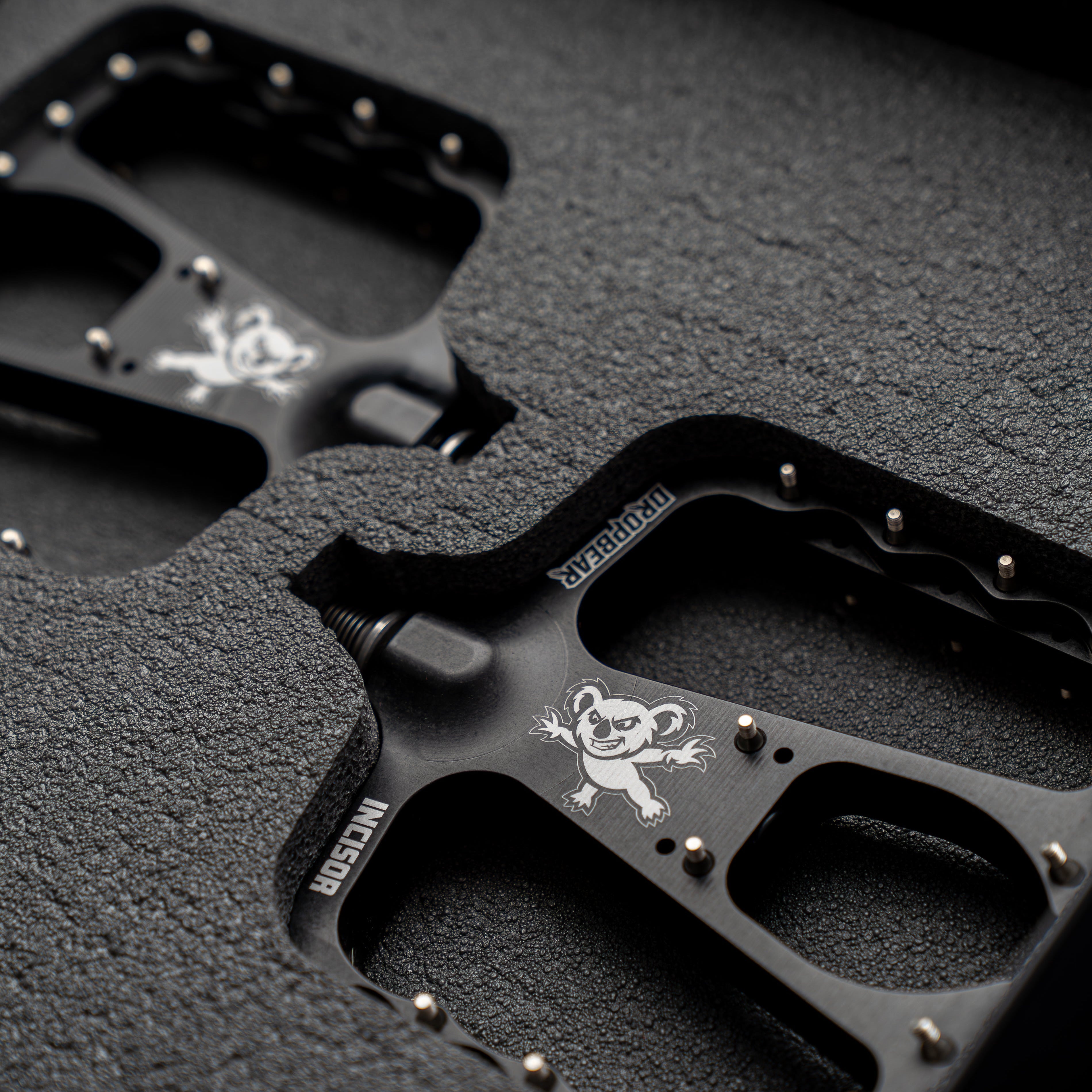 Dropbear pedals with koala logo on the pedal. Surrounded by a foam padding. Dark surrounding