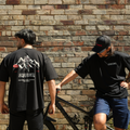 Two people wearing oversized mountain bike branded tees