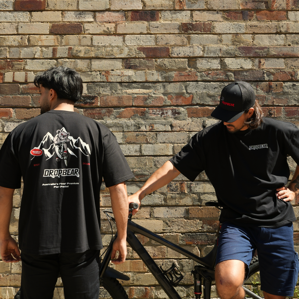 Two people wearing oversized mountain bike branded tees